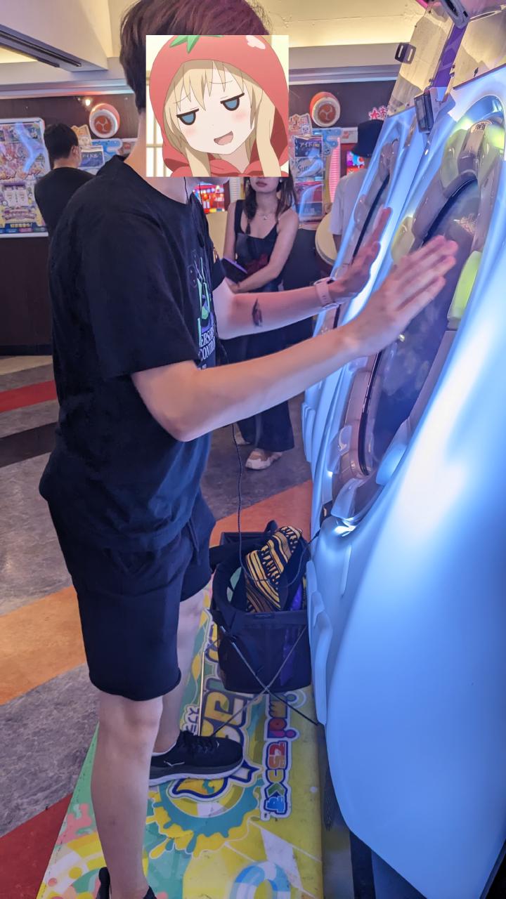 Kyuko playing an arcade game called Maimai DX