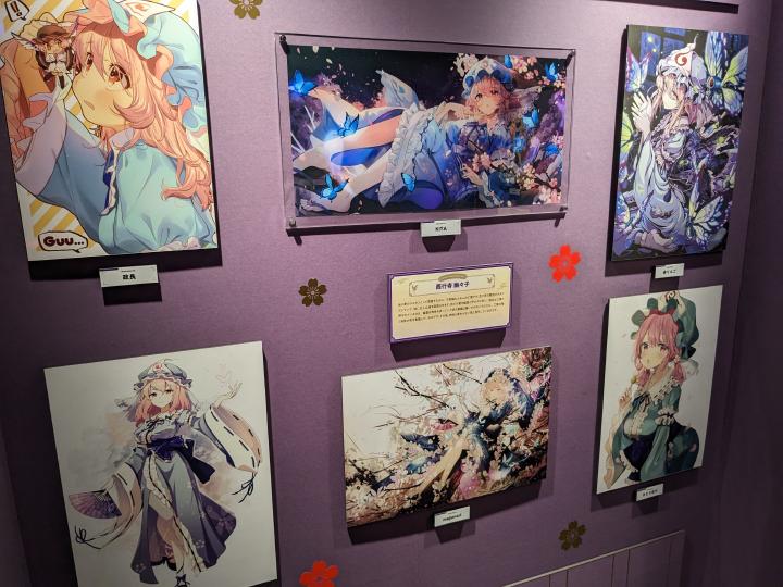 Works depicting Yuyuko Saigyouji drawn by different artists hanging on the wall